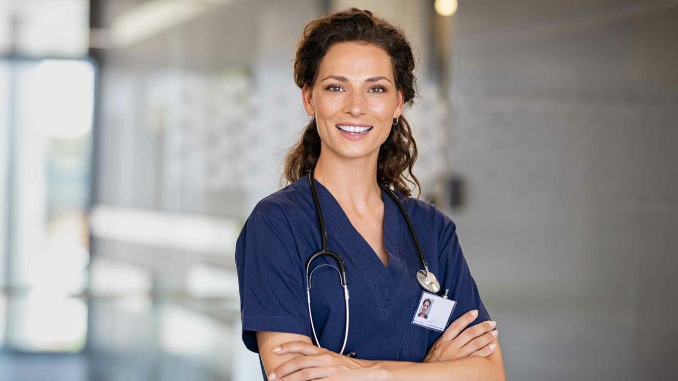 Pflegefachfrau HF lächelnd mit verschränkten Armen